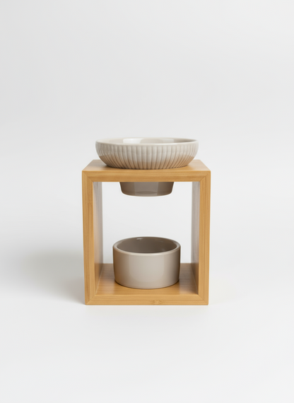 Quemador de cera artesanal con estructura de madera natural y cuenco superior de cerámica blanca acanalada.