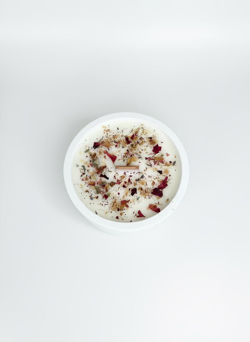 Vela decorativa artesanal en recipiente de resina ecológica blanca, decorada con flores secas naturales y mecha de madera 